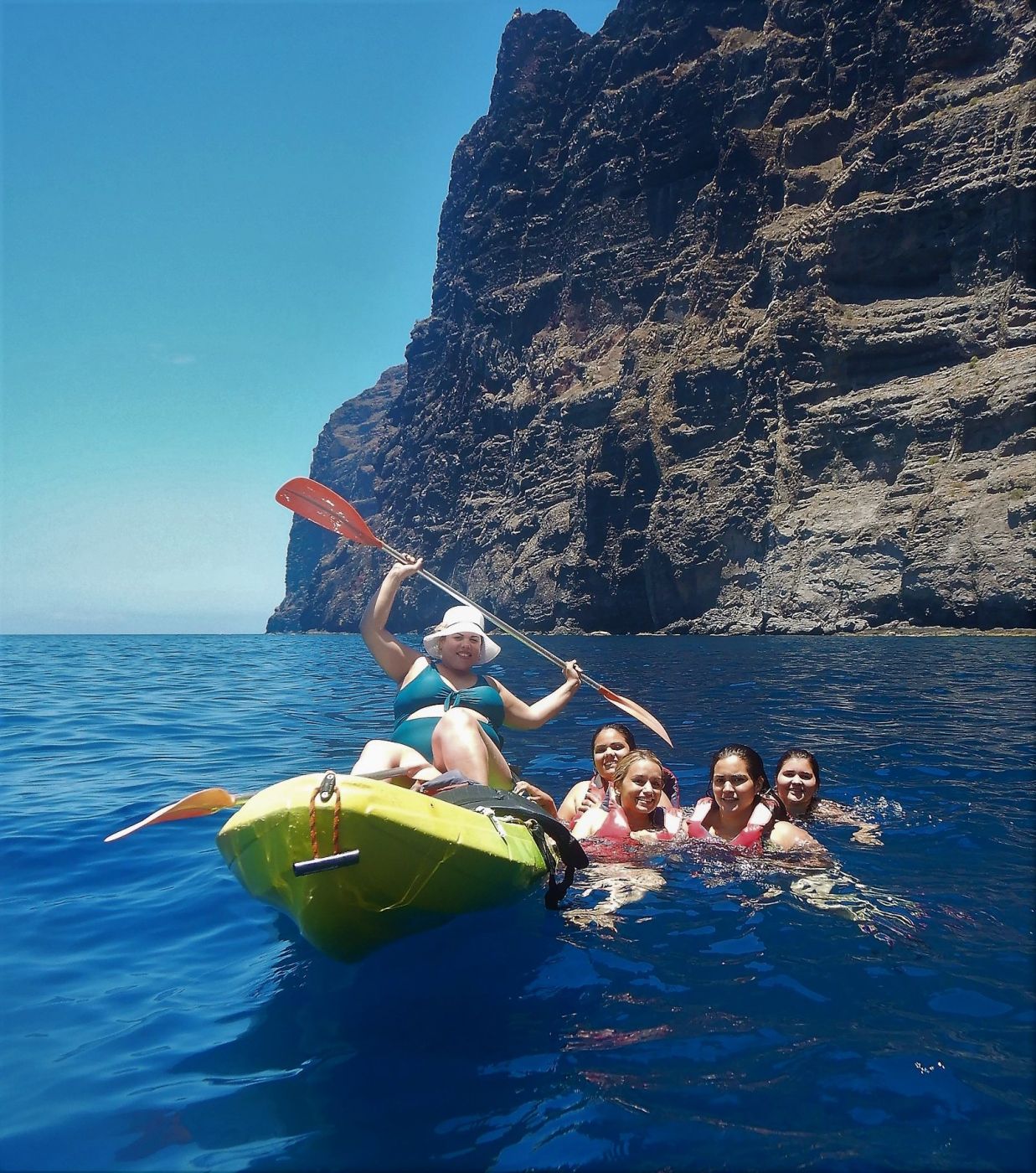 Persona en kayak y sus amigas nadando al lado