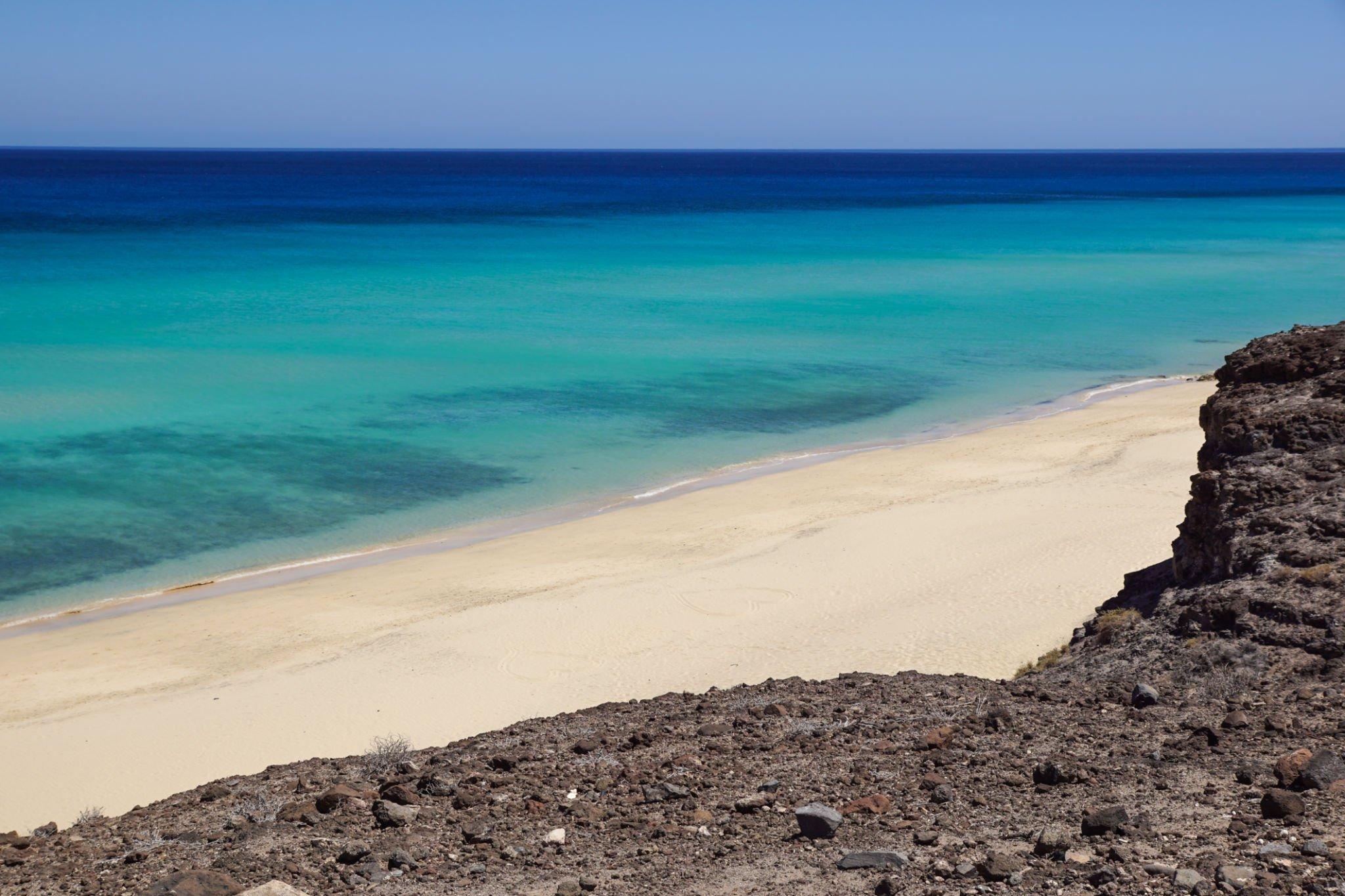 White sand and turquoise water seen from a cliff in Jandía