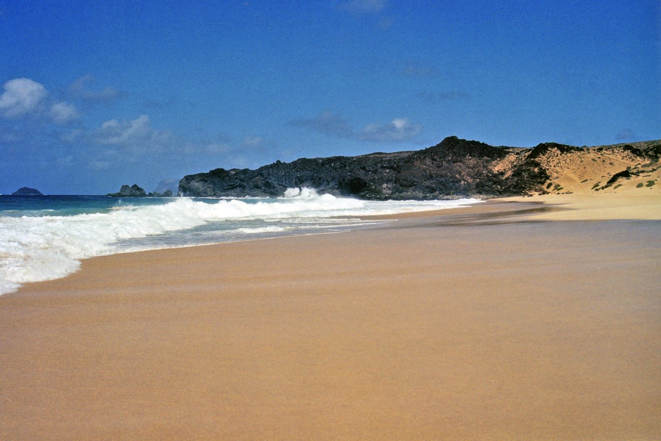 Arena dorada y aguas bravas en la Playa de las Conchas con Montaña Clara al fondo, La Graciosa
