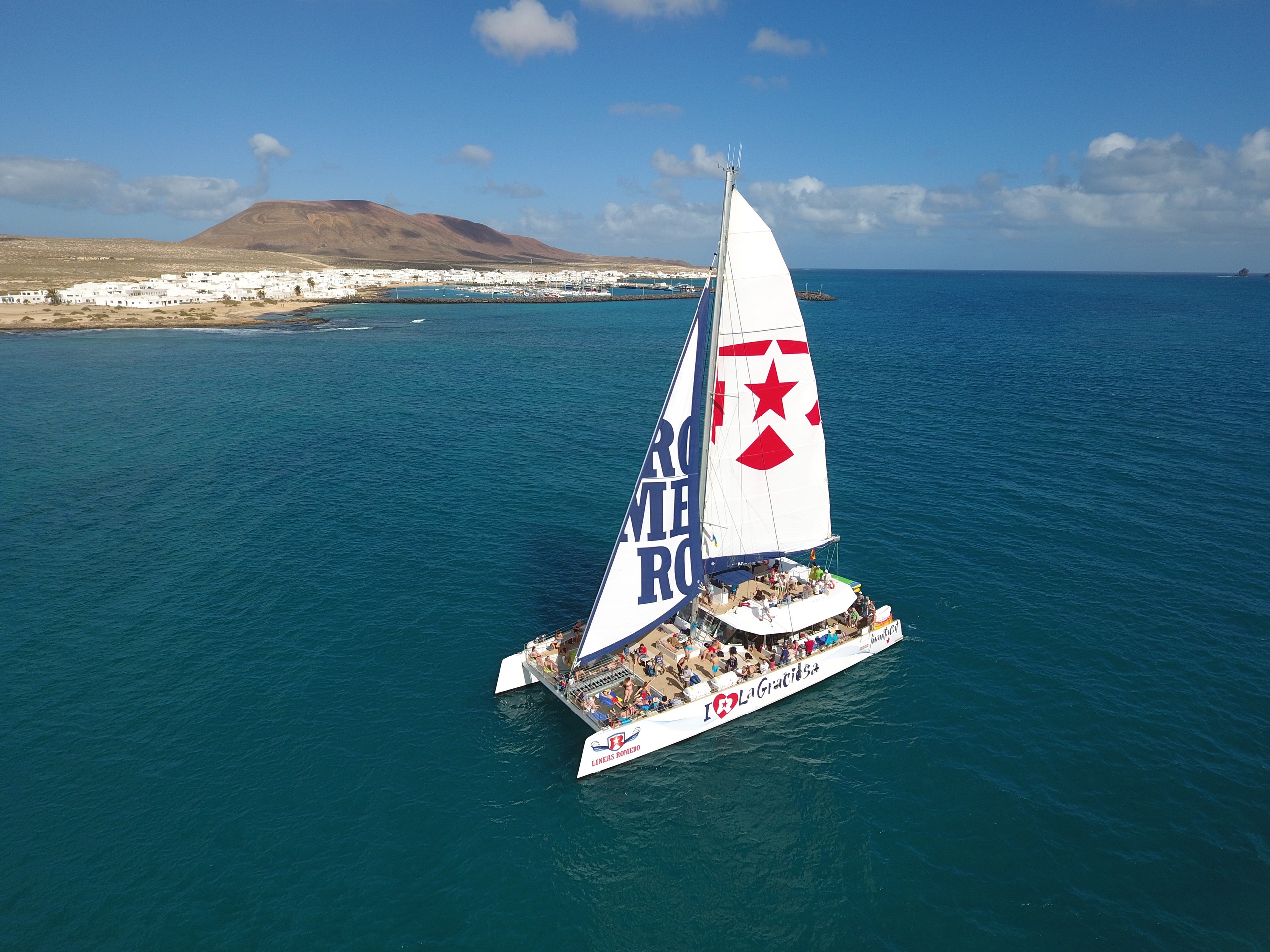 Catamarán navegando por las aguas turquesas junto a la costa de La Graciosa